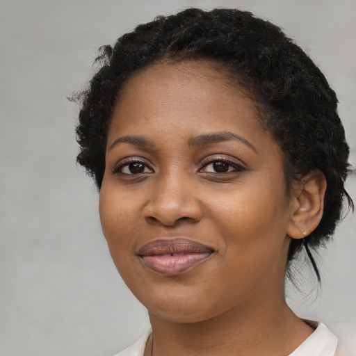 Joyful black young-adult female with medium  brown hair and brown eyes