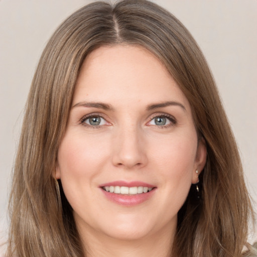 Joyful white young-adult female with long  brown hair and grey eyes