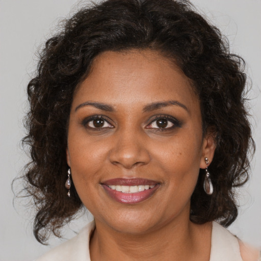 Joyful black young-adult female with medium  brown hair and brown eyes
