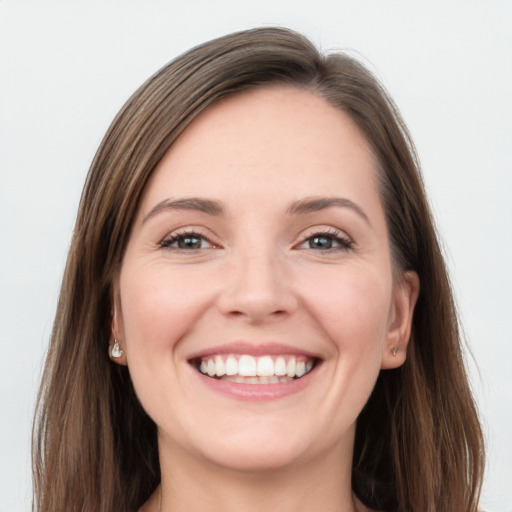 Joyful white young-adult female with long  brown hair and grey eyes