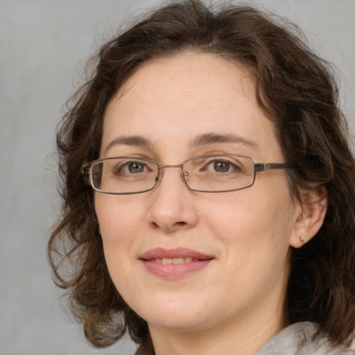 Joyful white adult female with medium  brown hair and green eyes