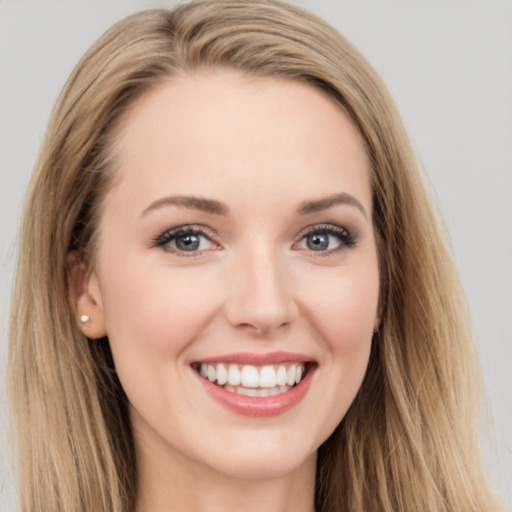 Joyful white young-adult female with long  brown hair and blue eyes