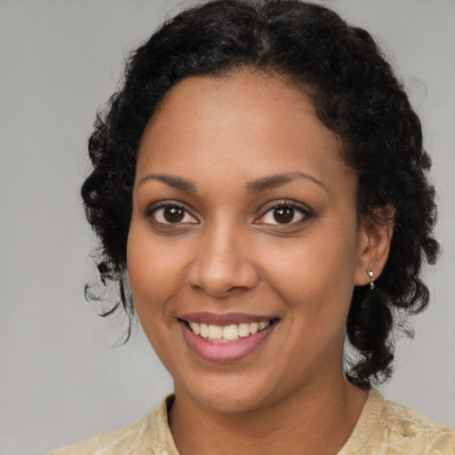 Joyful black young-adult female with medium  brown hair and brown eyes