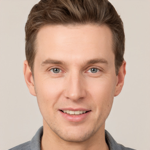 Joyful white young-adult male with short  brown hair and grey eyes