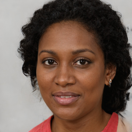 Joyful black young-adult female with medium  brown hair and brown eyes