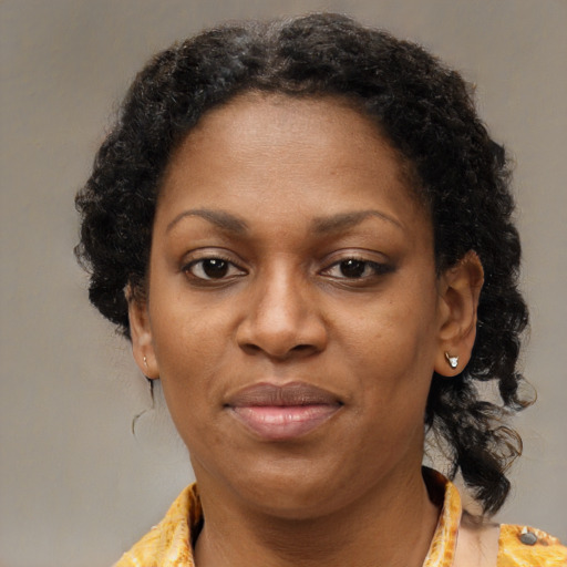 Joyful black adult female with medium  brown hair and brown eyes