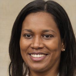 Joyful black young-adult female with long  brown hair and brown eyes