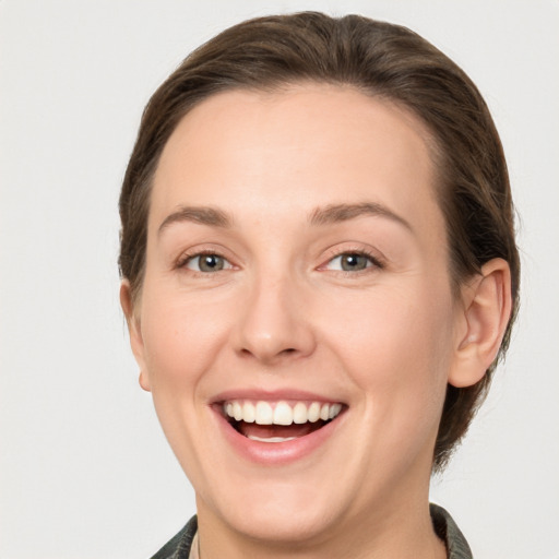 Joyful white young-adult female with medium  brown hair and grey eyes