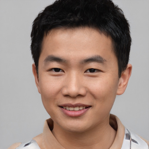 Joyful asian young-adult male with short  black hair and brown eyes