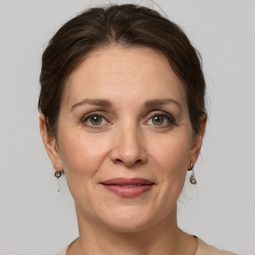 Joyful white adult female with medium  brown hair and grey eyes