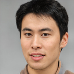 Joyful asian young-adult male with short  brown hair and brown eyes