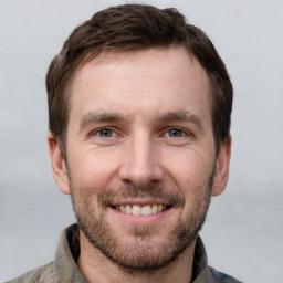 Joyful white adult male with short  brown hair and grey eyes