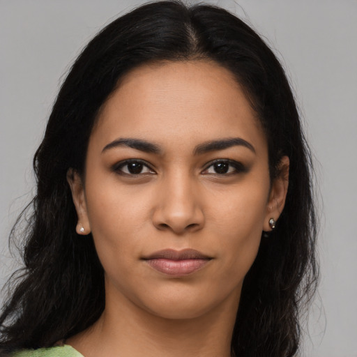 Joyful latino young-adult female with long  black hair and brown eyes