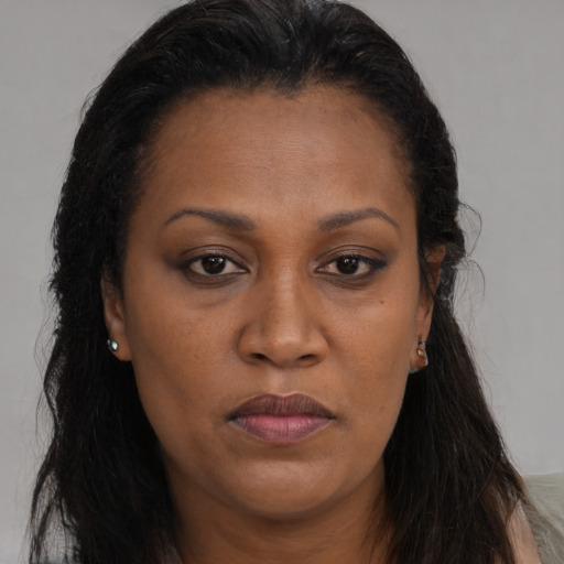 Joyful black adult female with long  brown hair and brown eyes
