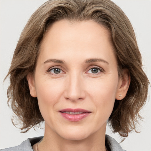 Joyful white adult female with medium  brown hair and grey eyes