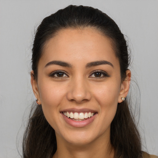 Joyful latino young-adult female with long  brown hair and brown eyes