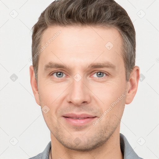 Joyful white young-adult male with short  brown hair and grey eyes