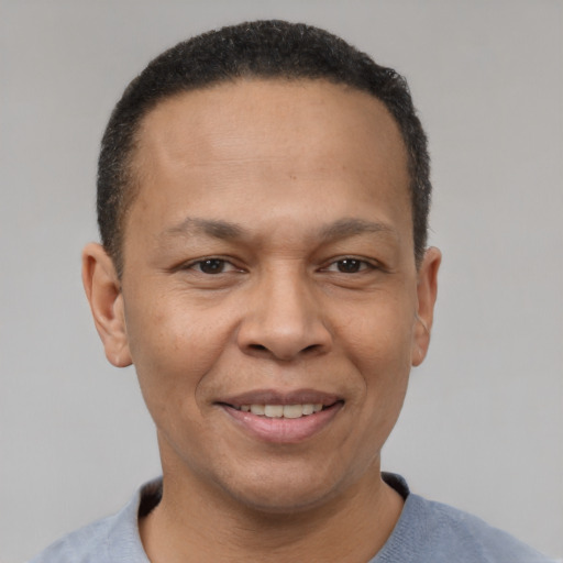 Joyful black adult male with short  black hair and brown eyes