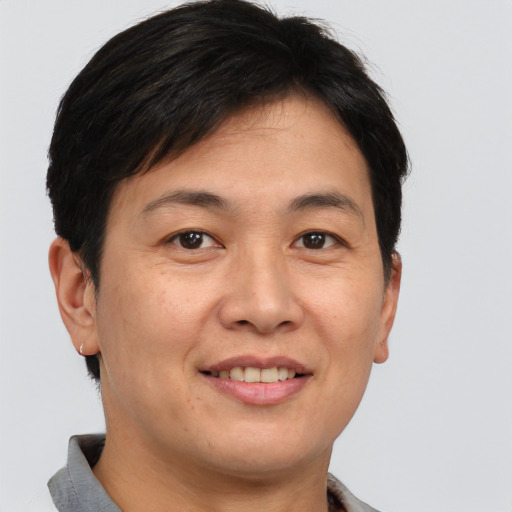 Joyful asian young-adult male with short  brown hair and brown eyes