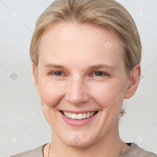 Joyful white young-adult female with short  brown hair and blue eyes