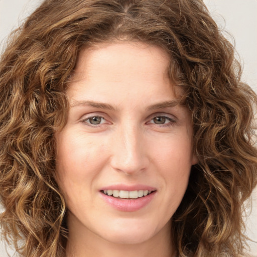 Joyful white young-adult female with long  brown hair and green eyes