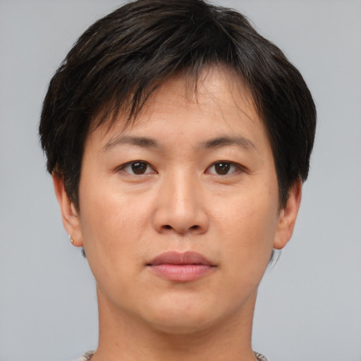 Joyful asian young-adult male with short  brown hair and brown eyes