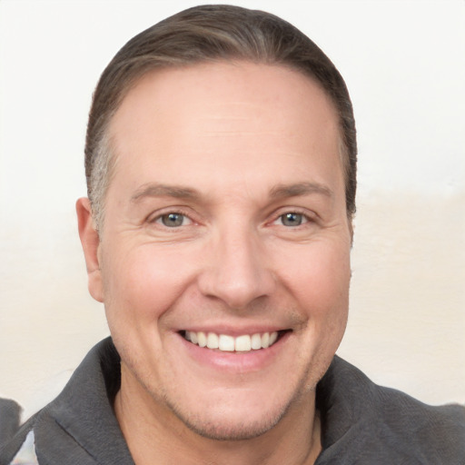 Joyful white adult male with short  brown hair and grey eyes