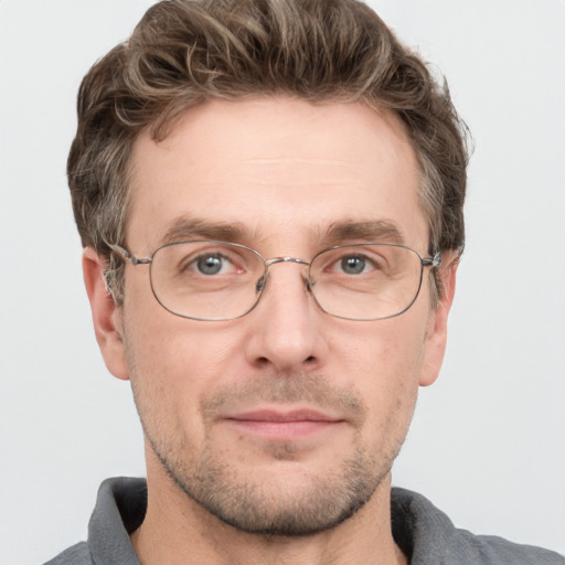 Joyful white adult male with short  brown hair and grey eyes