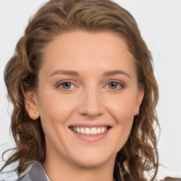 Joyful white young-adult female with long  brown hair and green eyes