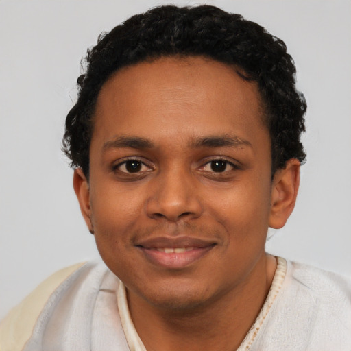 Joyful black young-adult male with short  black hair and brown eyes