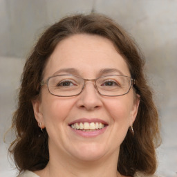 Joyful white adult female with medium  brown hair and blue eyes