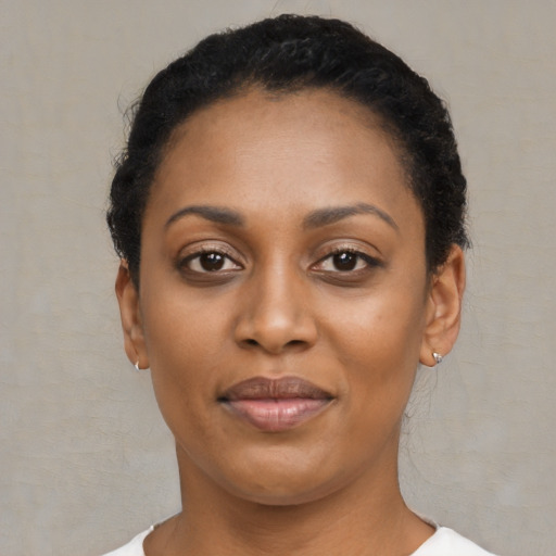 Joyful black young-adult female with short  black hair and brown eyes