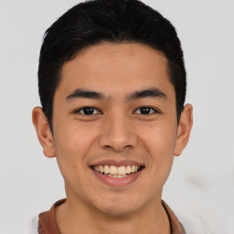 Joyful latino young-adult male with short  black hair and brown eyes