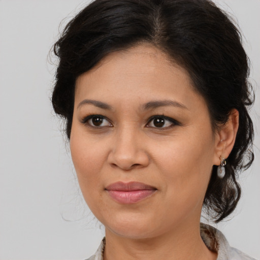 Joyful latino adult female with medium  brown hair and brown eyes