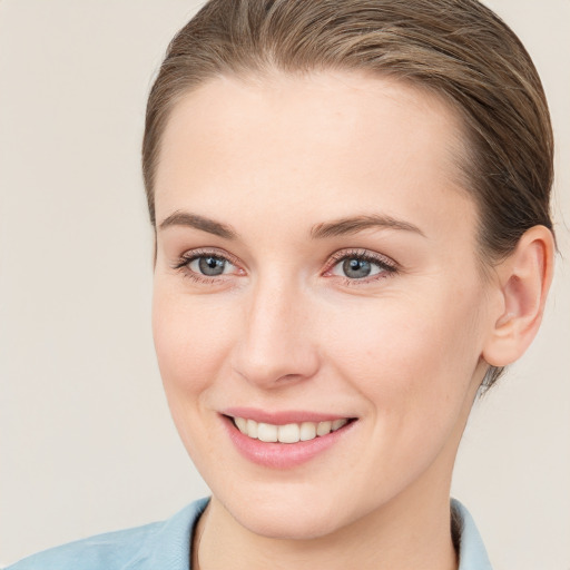 Joyful white young-adult female with short  brown hair and grey eyes