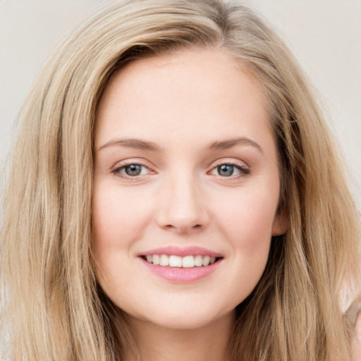 Joyful white young-adult female with long  brown hair and blue eyes