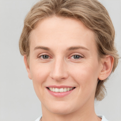 Joyful white young-adult female with medium  brown hair and blue eyes