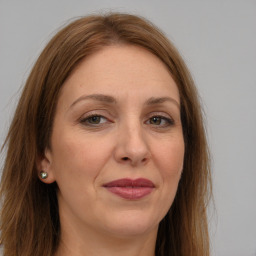 Joyful white adult female with long  brown hair and grey eyes