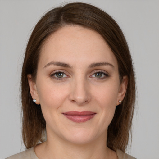 Joyful white young-adult female with medium  brown hair and grey eyes