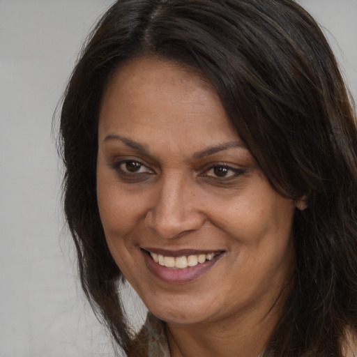 Joyful white adult female with long  brown hair and brown eyes