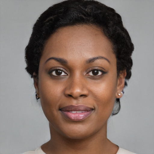 Joyful black young-adult female with short  black hair and brown eyes