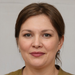 Joyful white adult female with medium  brown hair and grey eyes