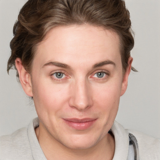 Joyful white young-adult female with short  brown hair and blue eyes