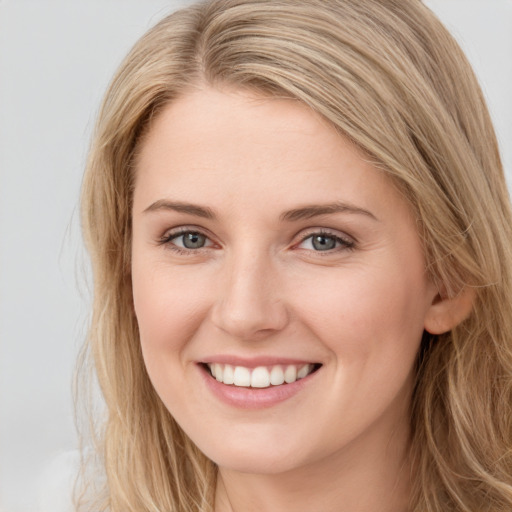 Joyful white young-adult female with long  brown hair and blue eyes