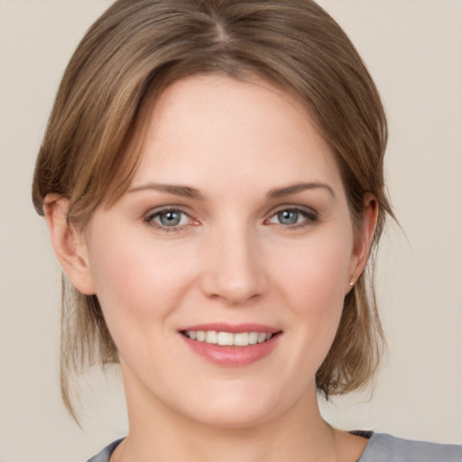 Joyful white young-adult female with medium  brown hair and grey eyes