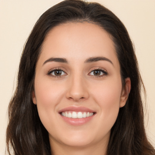 Joyful white young-adult female with long  brown hair and brown eyes