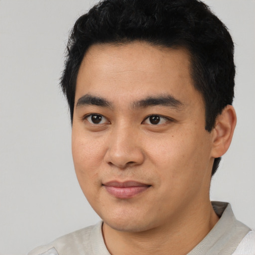 Joyful asian young-adult male with short  black hair and brown eyes
