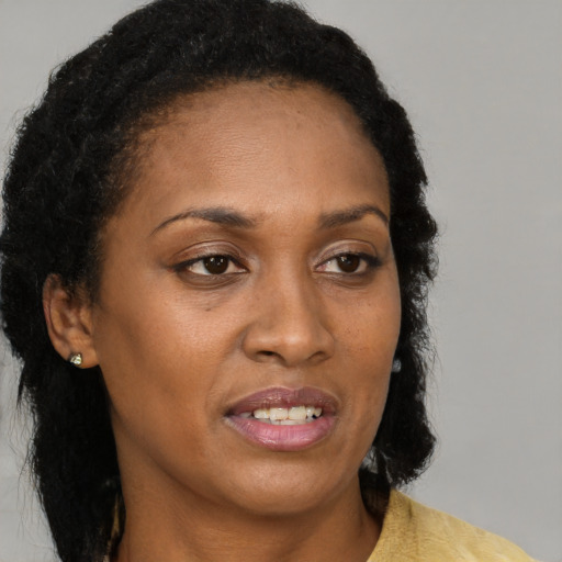 Joyful black adult female with medium  brown hair and brown eyes