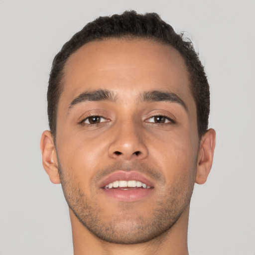 Joyful latino young-adult male with short  brown hair and brown eyes