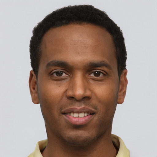 Joyful black young-adult male with short  black hair and brown eyes